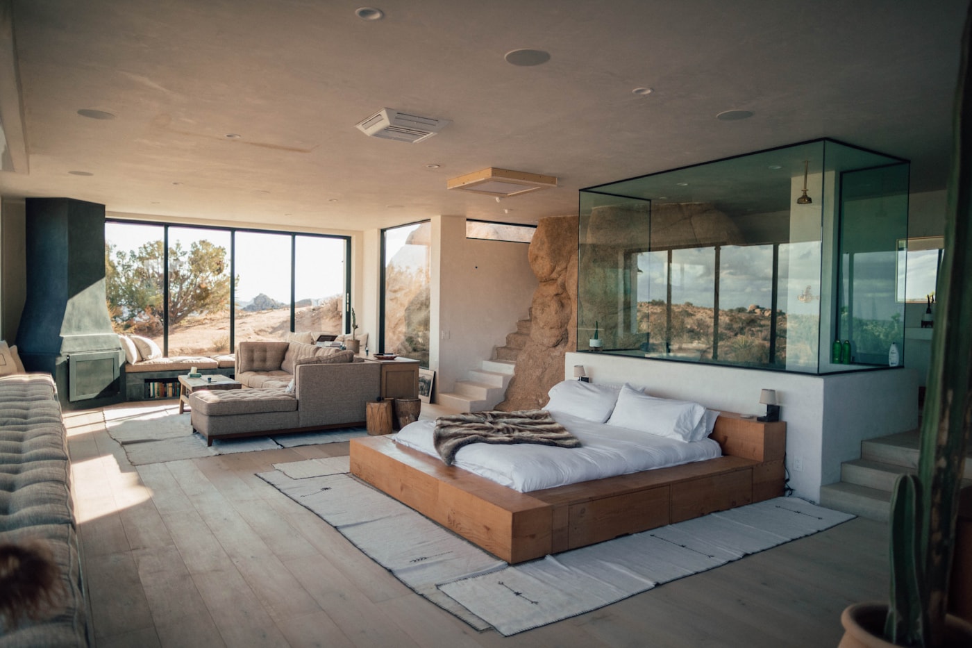 Primary suite with a timber-framed glass wall and soft evening light