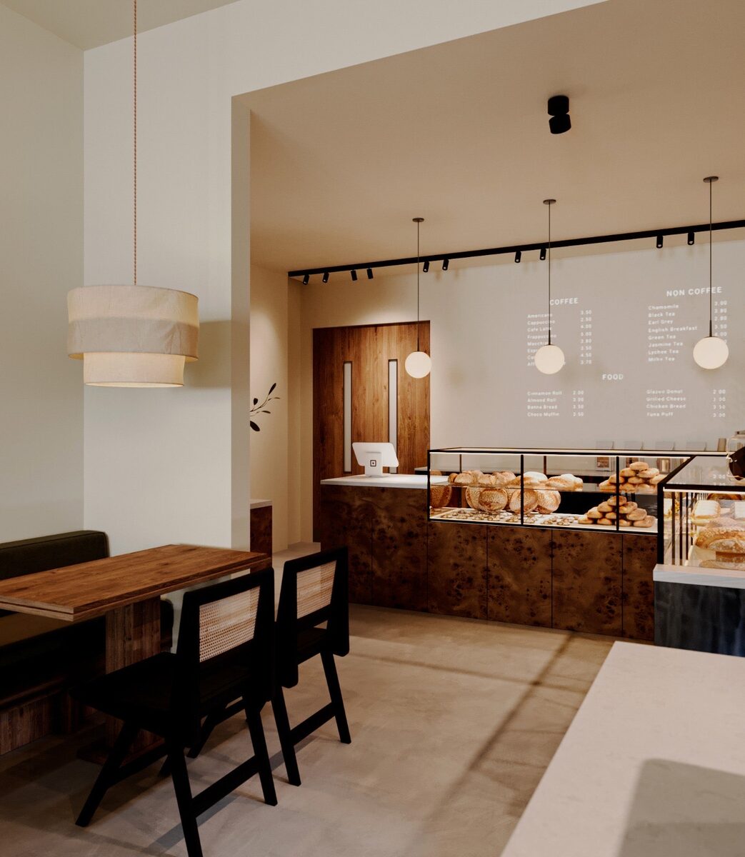 The counter in daylight — pale walls, burl timber, and the pastry case at the turn