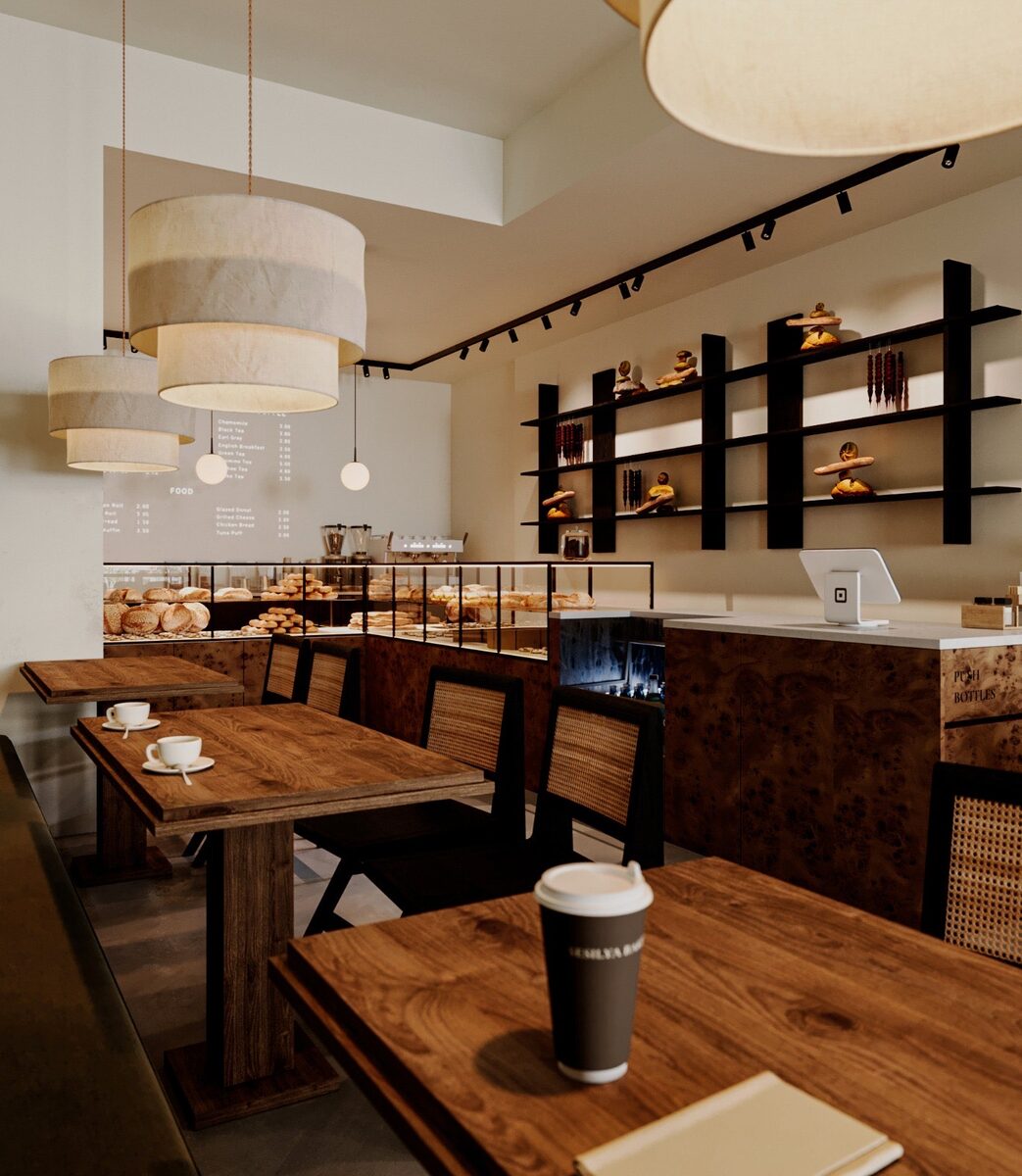 Wood tables and caned chairs under drum pendants, the counter and shelving beyond