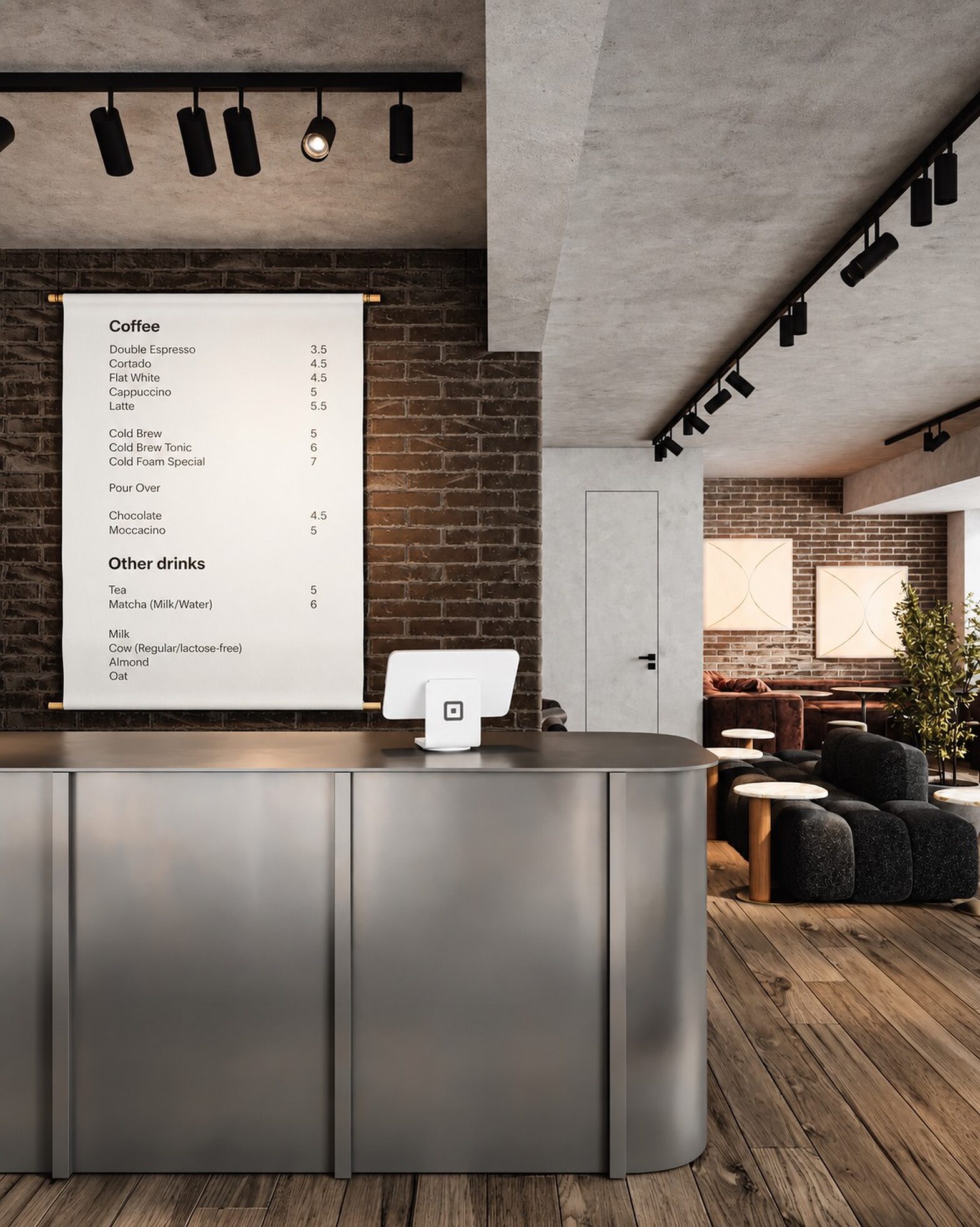 The stainless steel coffee counter beneath a hanging menu board, set against exposed brick