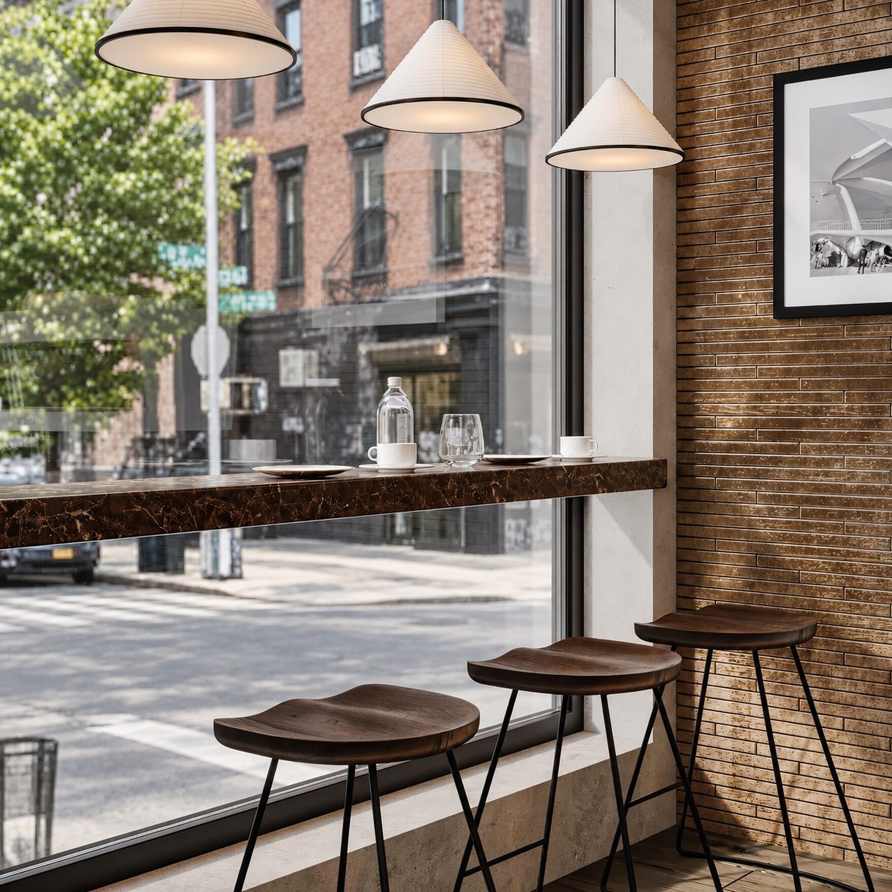 A marble window counter with stools looking onto the Williamsburg street through full-height glazing