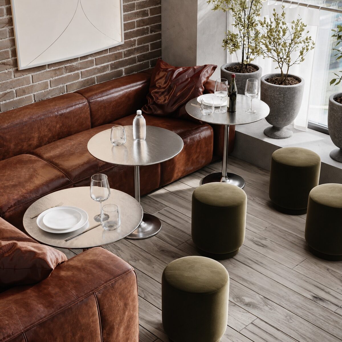 A corner banquette with marble and steel side tables and olive poufs