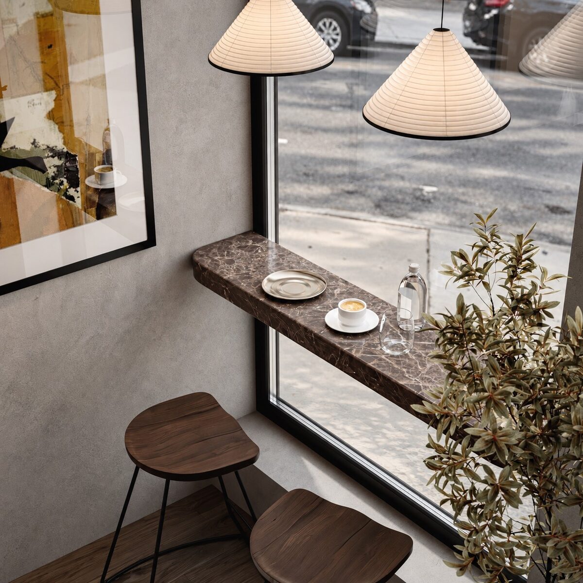 The marble window ledge with a coffee served, paper pendants above and the street beyond
