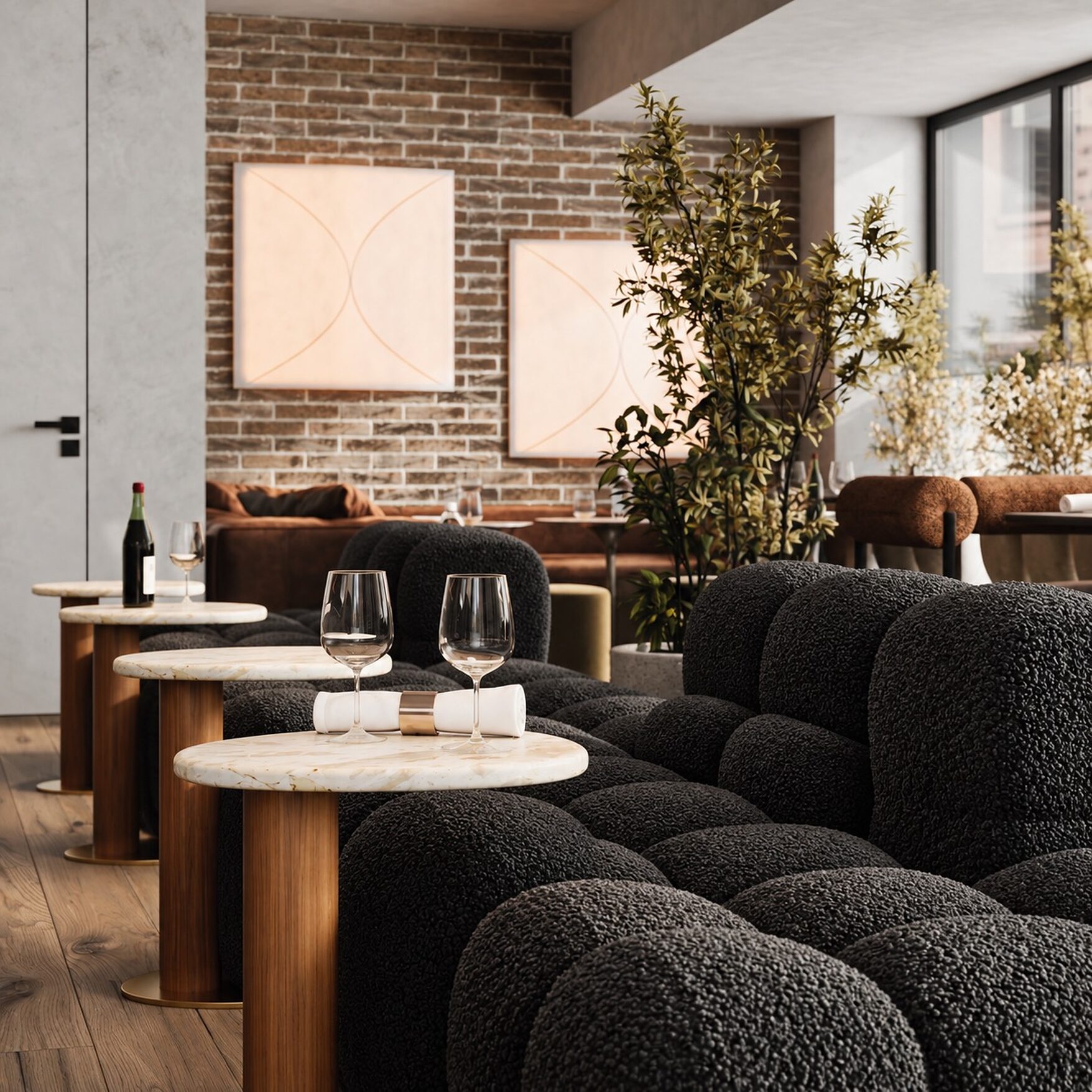 Lab148’s main room — black bouclé banquettes and marble-topped tables against exposed brick, with two backlit artworks and planting at the window