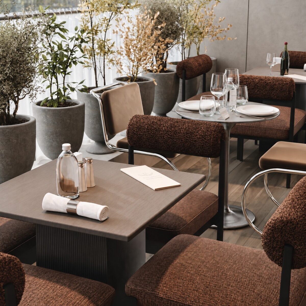 A dining table laid with linen, ringed by bouclé chairs and tall planters