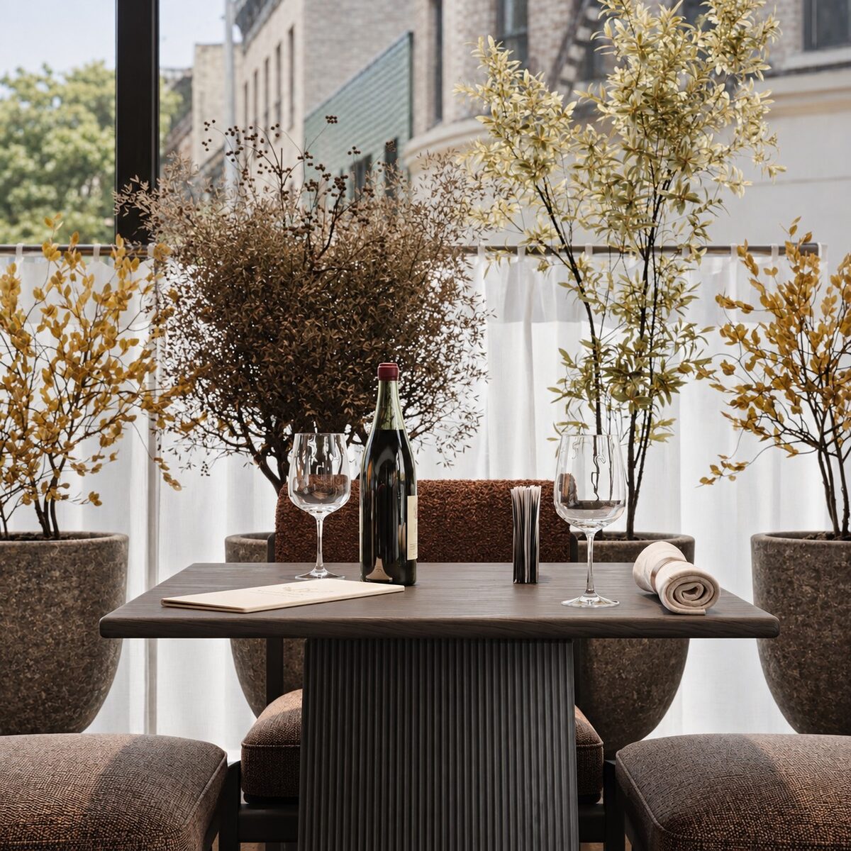 A dark table set with wine, framed by planting against the window